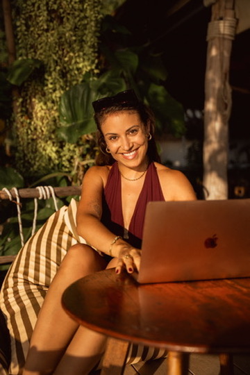 Corinna lachend mit Laptop im Freien